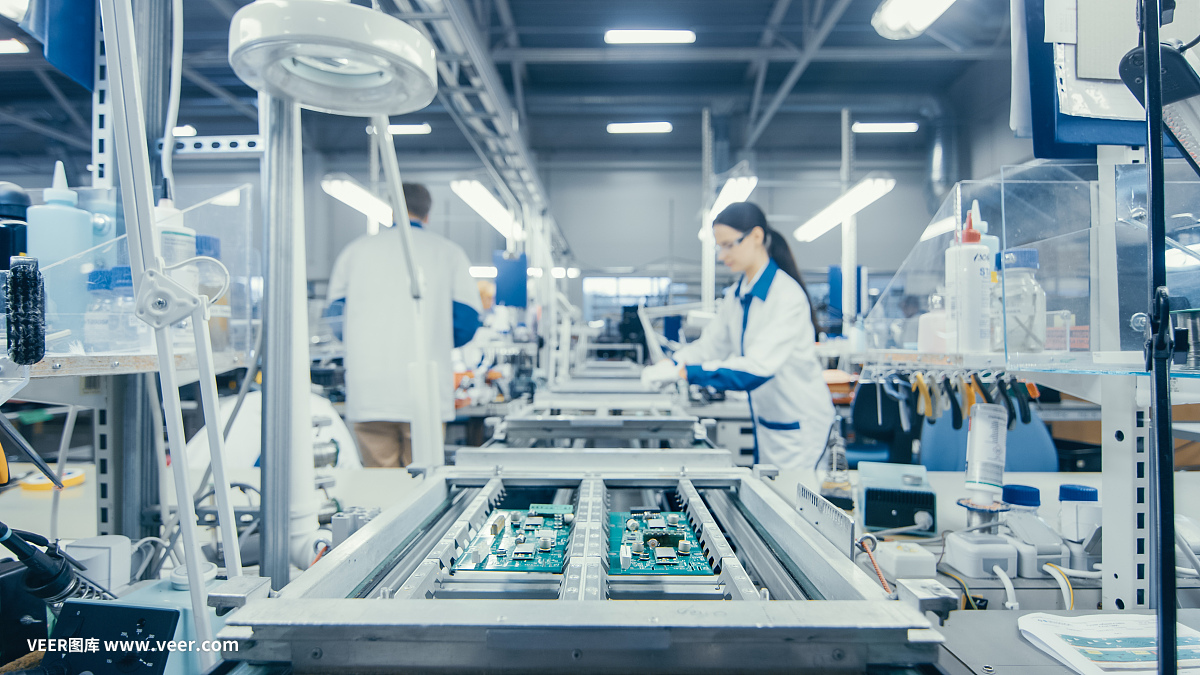 圖為電子廠工人在裝配線上手工組裝電路板。高科技工廠設(shè)施。